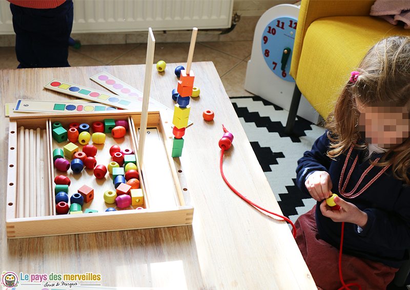 enfiler des perles en bois sur un lacet 