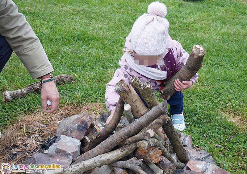 enfant qui prépare un feu de bois