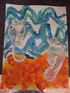 Empreintes de pieds réalisées avec un mélange de sable et de peinture 