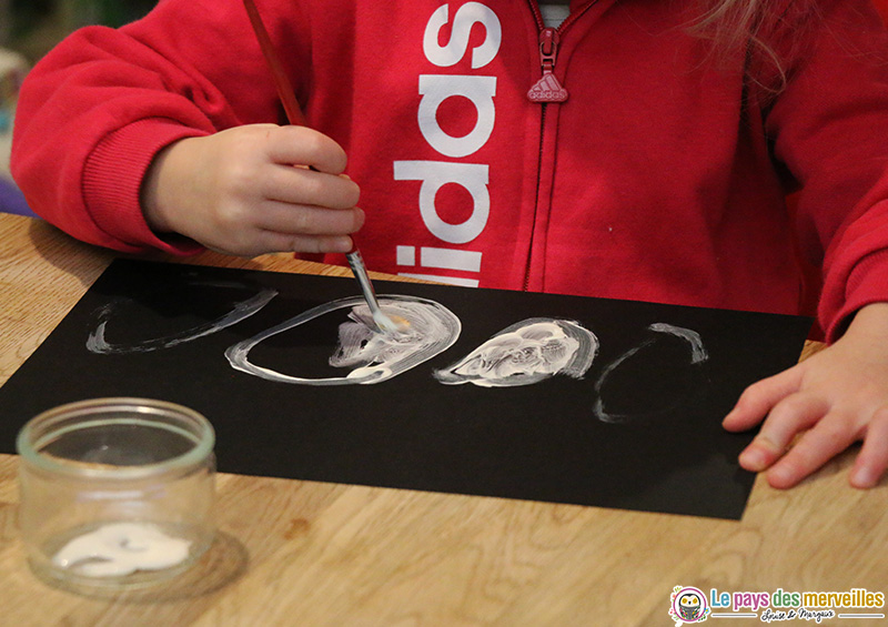 Gouache blanche sur une feuille noire