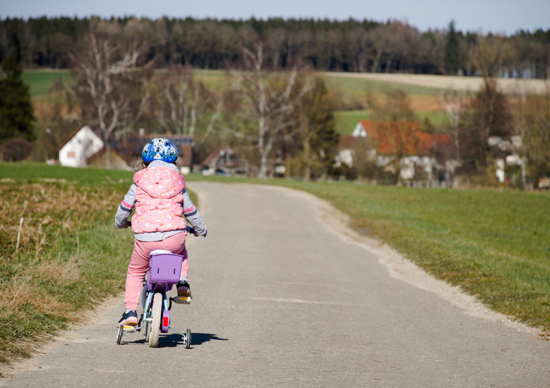 enfant qui fait du vélo avec stabilisateurs