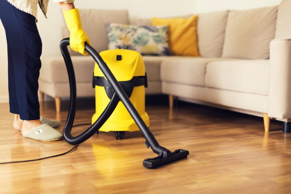 femme de ménage qui passe l'aspirateur dans le salon