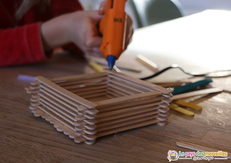 Coller des bâtonnets de bois pour fabriquer une mangeoire