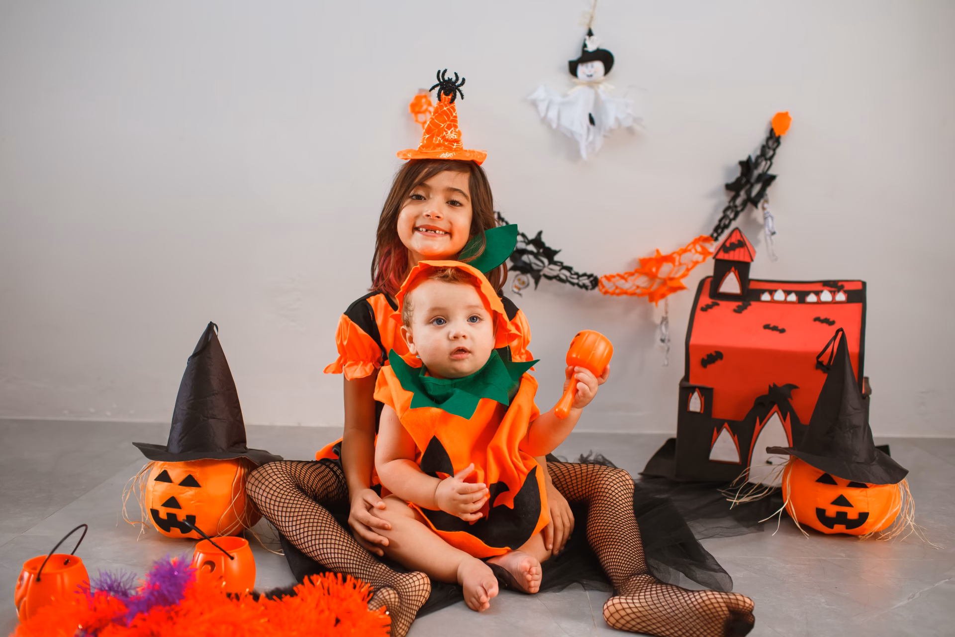 Enfants déguisés pour Halloween en sorcière et citrouille dans une décoration festive