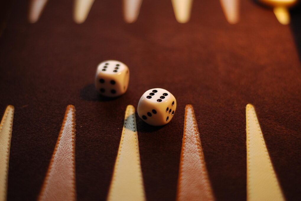 Deux dés posés sur un plateau de backgammon en bois