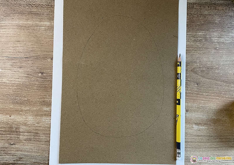 Dessiner un œuf de Pâques au crayon sur une feuille marron