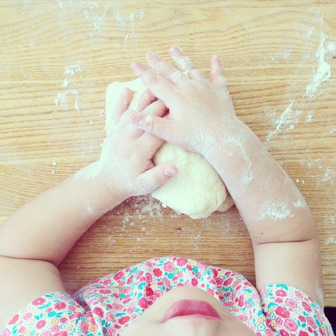 enfant qui pétrit une pâte à pain 