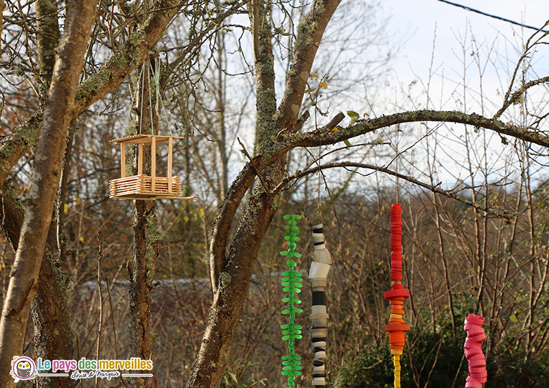 mangeoire avec des bâtonnets en bois pour les oiseaux du jardin