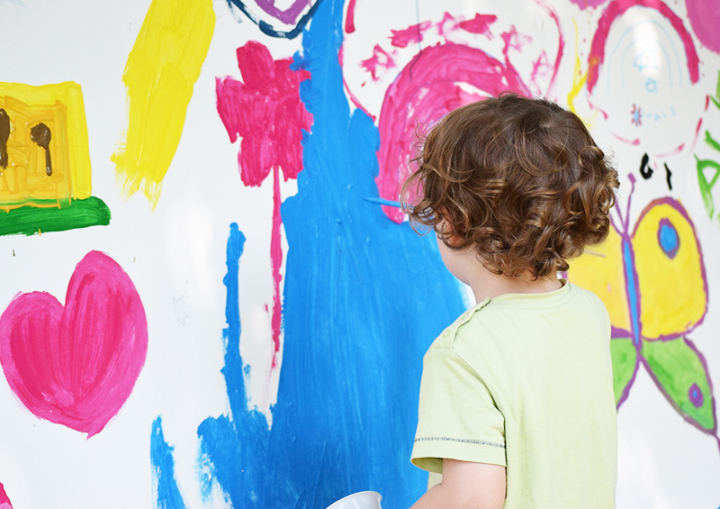 occuper ses enfants avec de la peinture sur un mur recouvert de papier