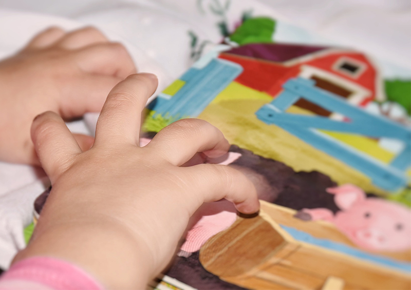 main d'enfant qui manipule un livre