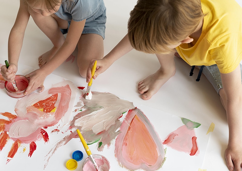 enfants qui font de la peinture sur le sol