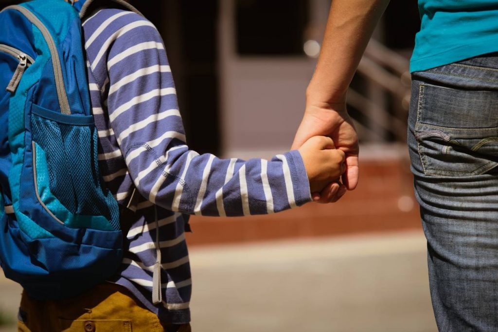 adulte et enfant main dans la main